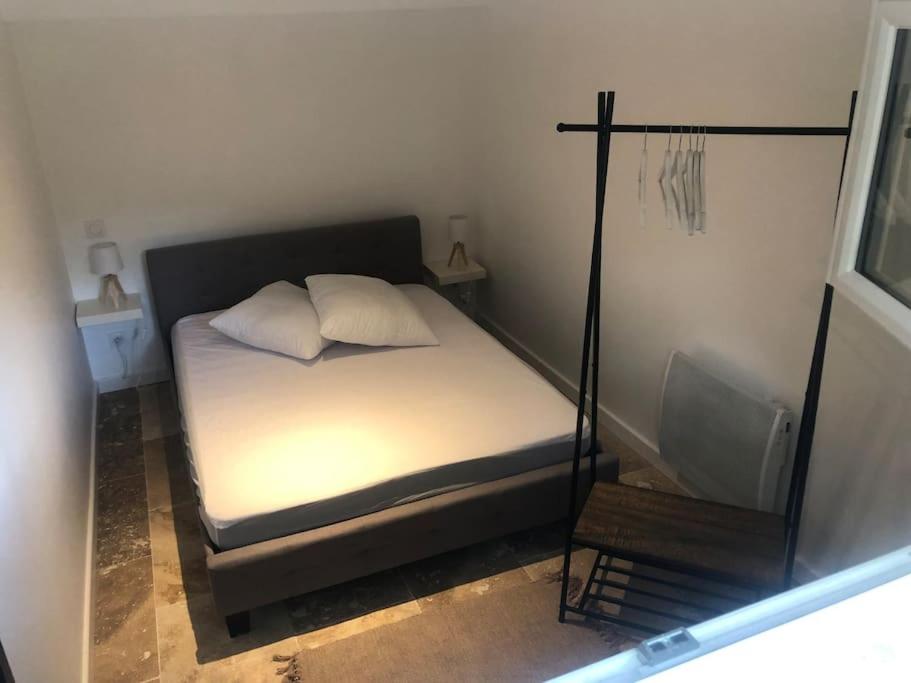 Dormitorio pequeño con cama y espejo en Bienvenue « À l’ombre du figuier » en Pieusse