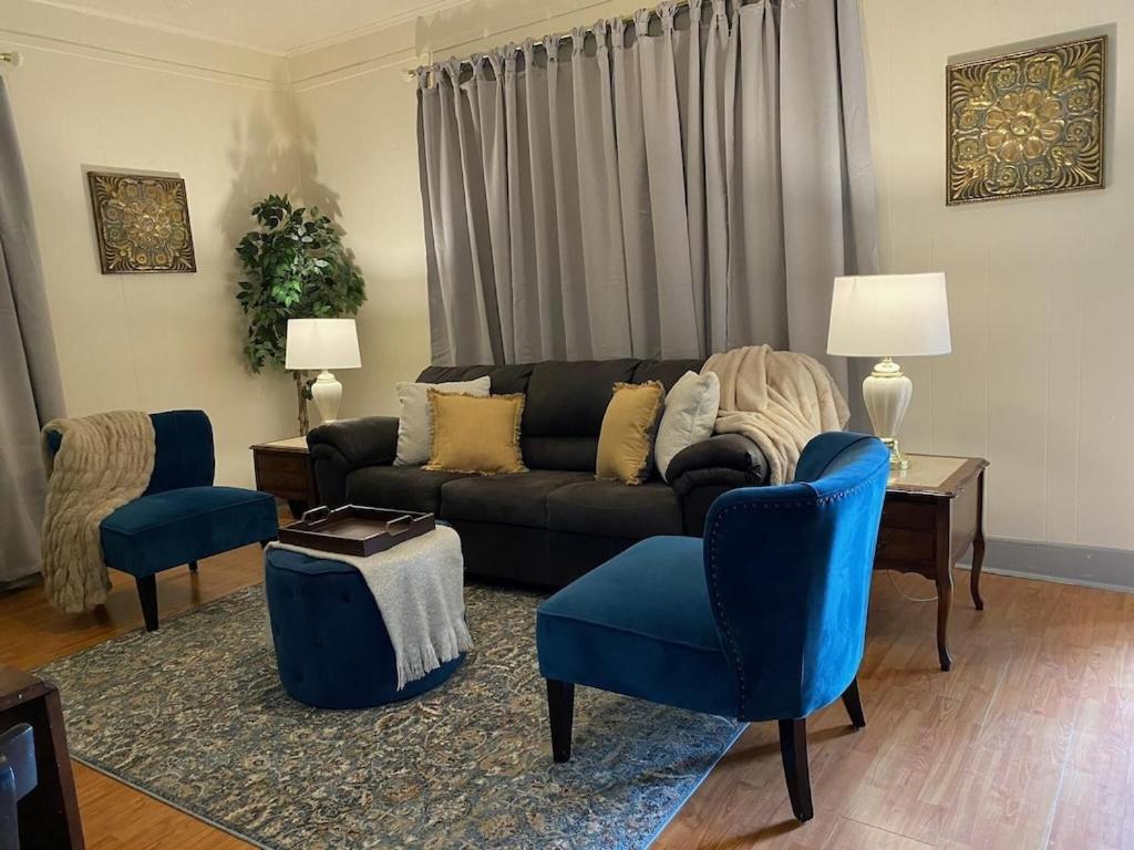 sala de estar con sofá negro y sillas azules en Oui! Not Your Grandmother's Property en Knoxville