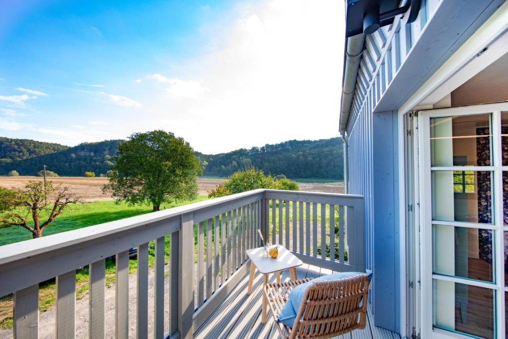 einen Balkon mit einem Tisch und Stühlen auf einem Haus in der Unterkunft Traumhaftes Gästehaus an Elberadweg und Bastei in Rathen