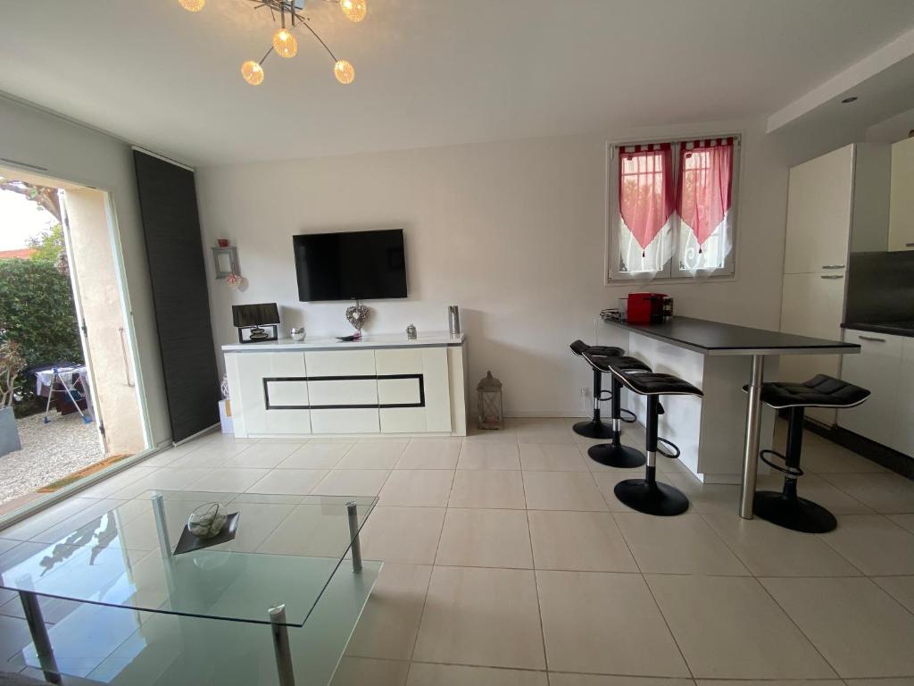a living room with a glass table and stools at Les Lones avec jardin in Six-Fours-les-Plages