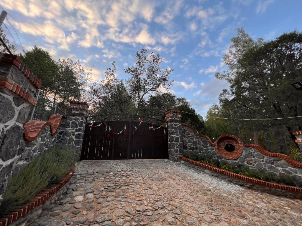 a gate to a house with a stone driveway at Un rincón en Huasca de Ocampo "El Principio" in Huasca de Ocampo