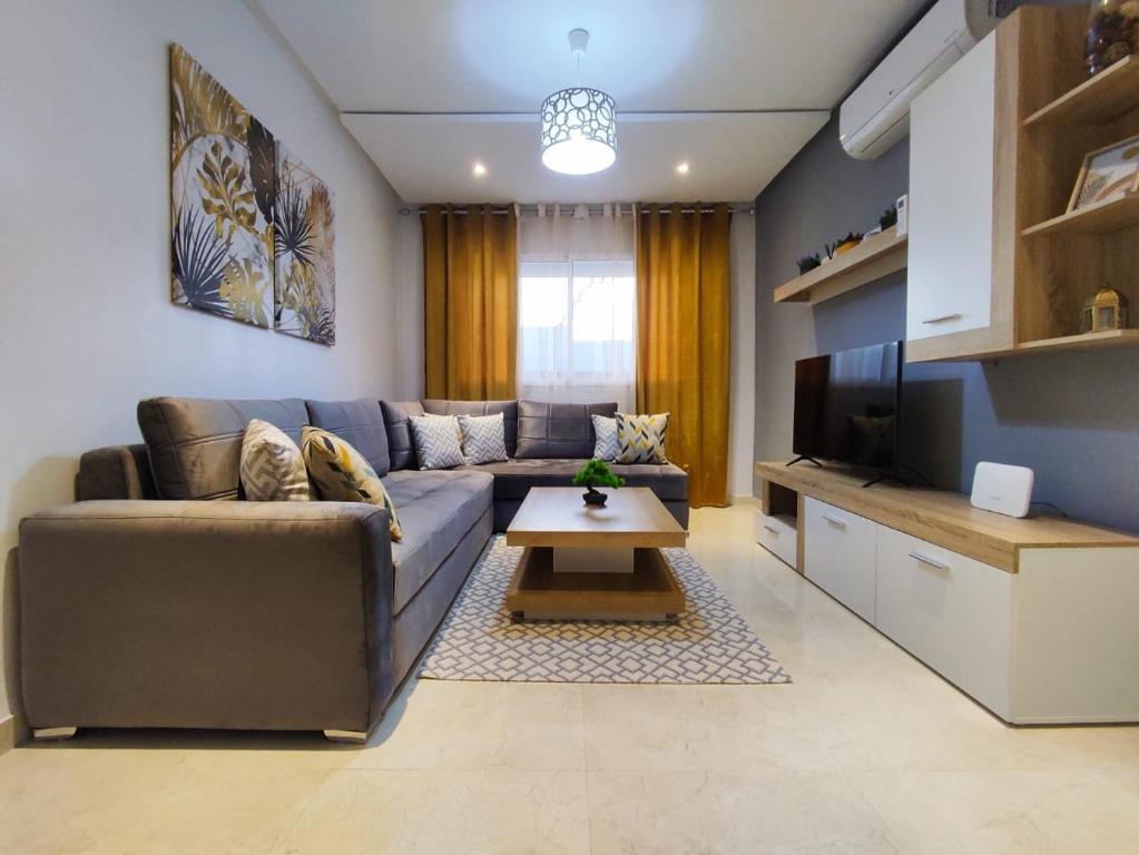 een woonkamer met een bank en een tv bij DLX01 - Appartement Deluxe bien équipé- Centre Ville Oujda in Oujda