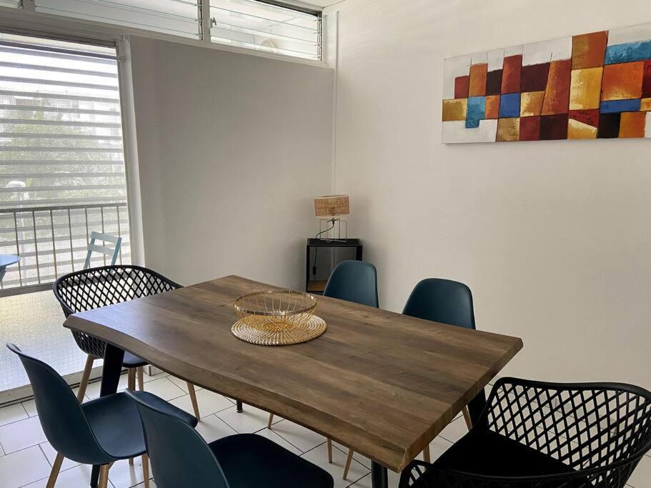 - une table et des chaises en bois dans l'établissement Appartement moderne, 2 chambres, proche aéroport • CHU • port, à Les Abymes