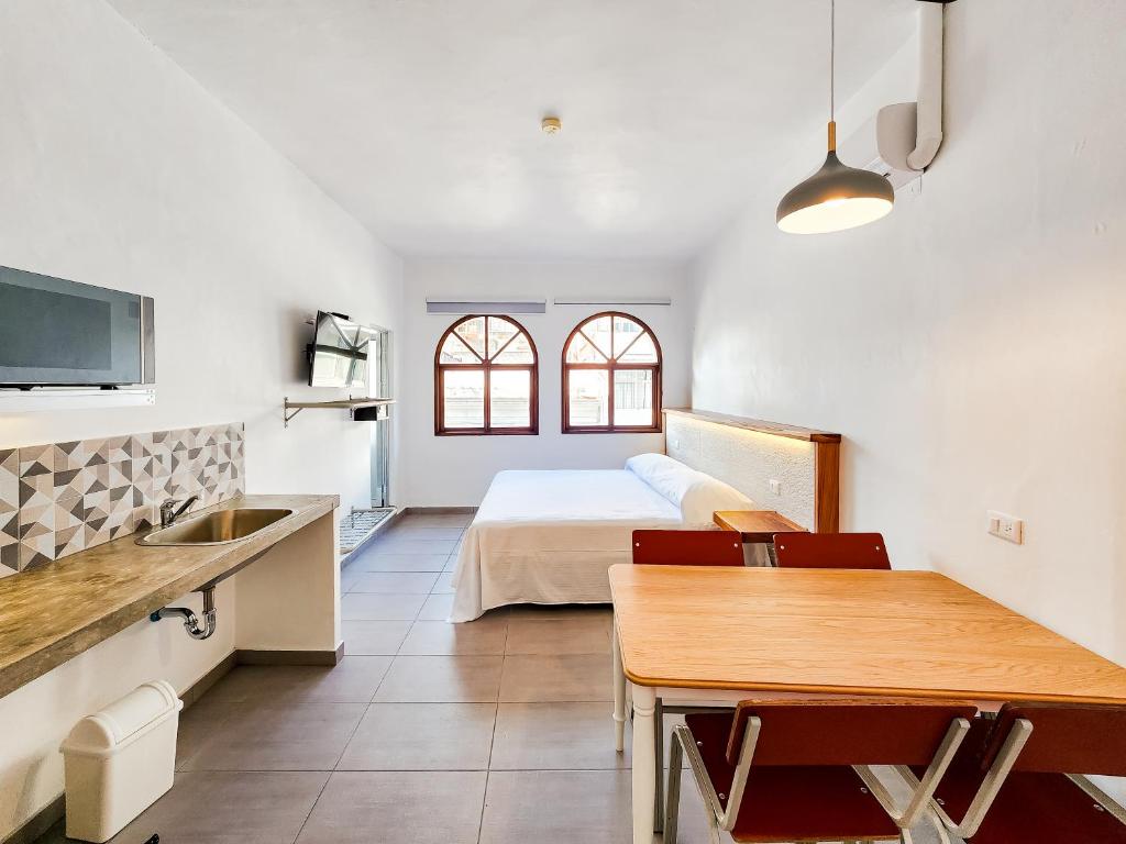 a kitchen and a bedroom with a bed and a table at Niebla Suites in Xalapa