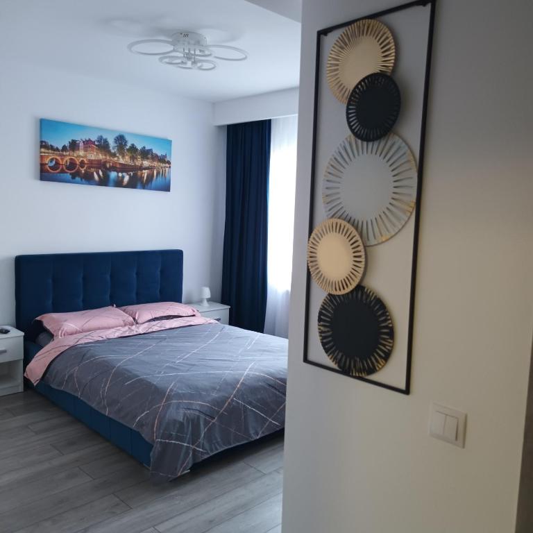 una camera da letto con un letto con testiera blu e specchi di Studio Acasă a Sibiu