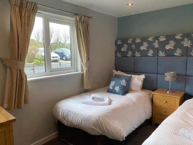 a small bedroom with a bed and a window at Trevone House with Hot Tub on Retallack Resort in Padstow