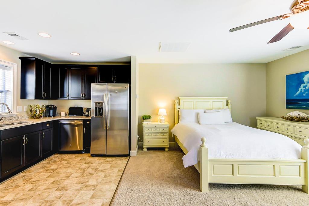 1 Schlafzimmer mit einem weißen Bett und einer Küche in der Unterkunft Southern Charm Getaway in Charleston