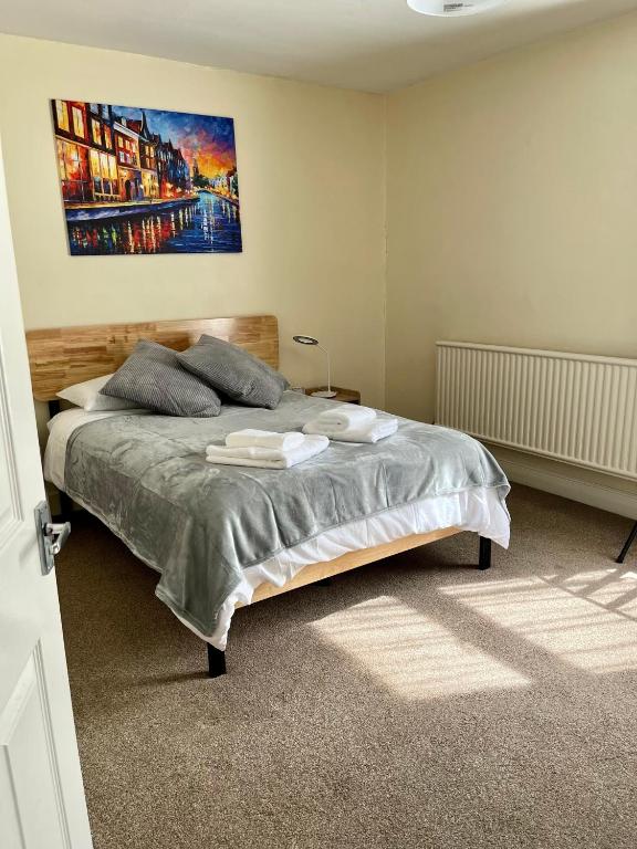 1 dormitorio con 1 cama con 2 toallas en Victorian house between cathedral, river and station, en Ely