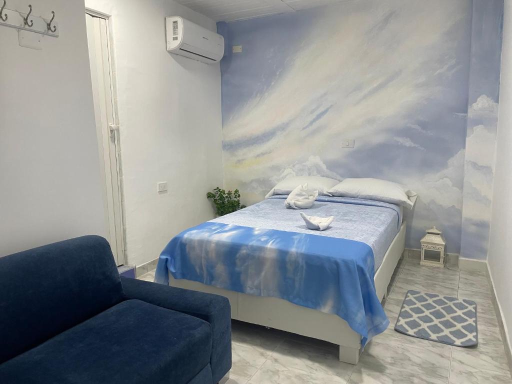 a bedroom with a blue bed and a chair at Hotel Casa Cielo Cartagena in Cartagena de Indias