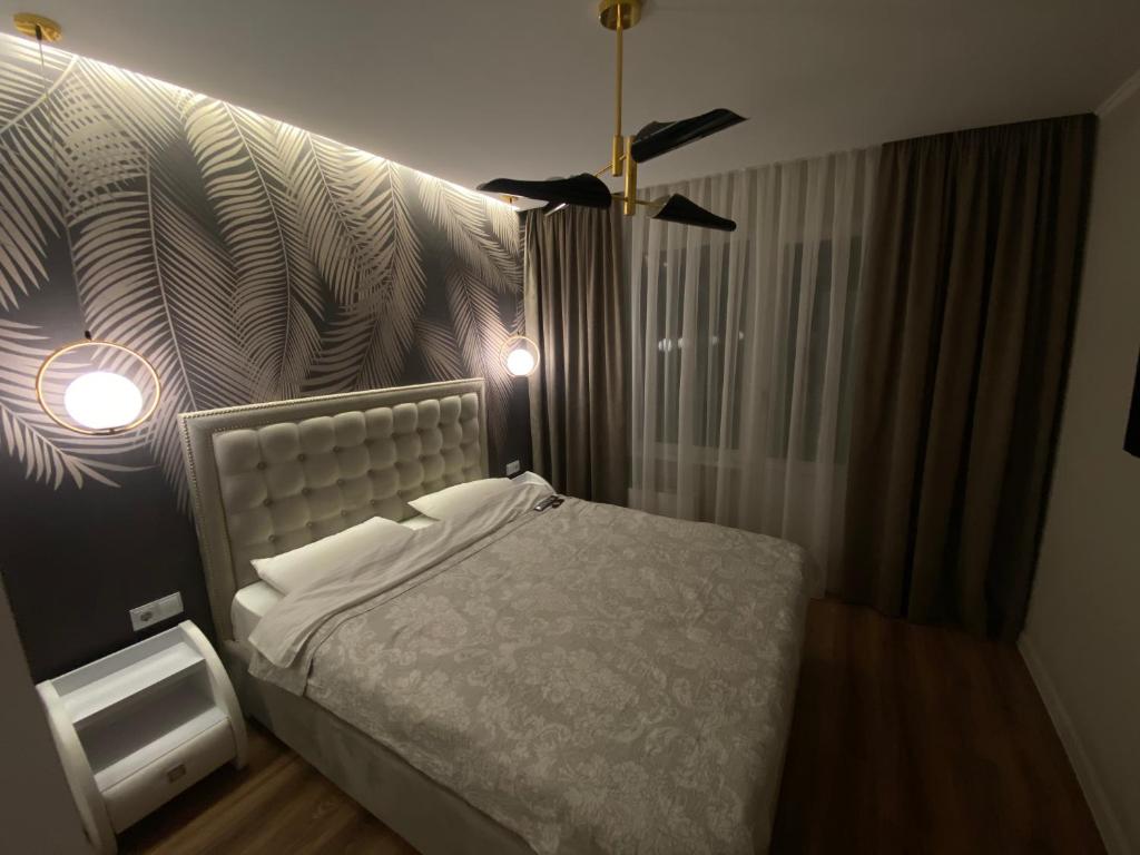 1 dormitorio con cama y pared en Sweethome Ciocana, en Chişinău