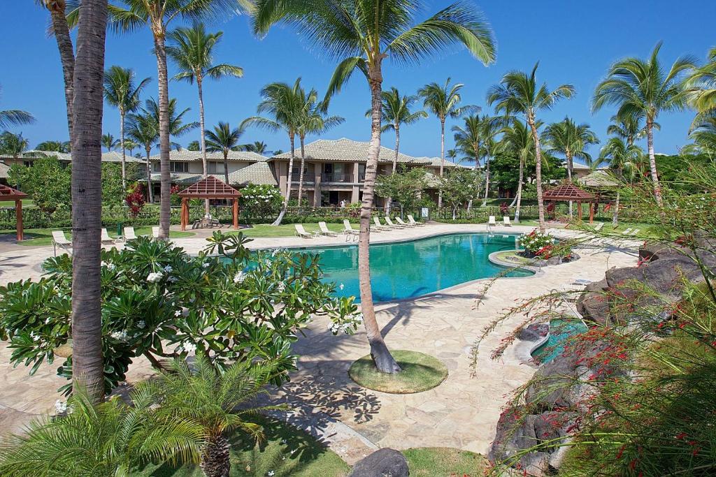 a pool at a resort with palm trees at Fairways at Mauna Lani by South Kohala Management in Waikoloa