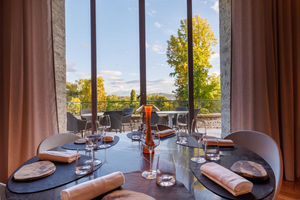 a table with wine glasses and a view of a balcony at Hôtel Villa Navarre in Pau