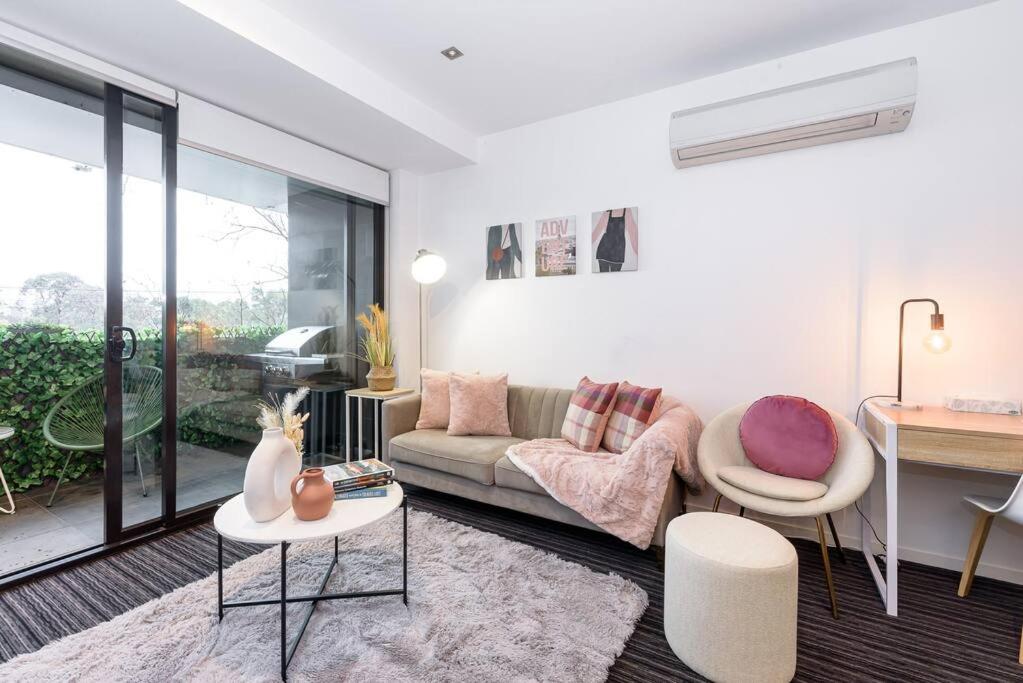 uma sala de estar com um sofá e uma mesa em Trendy 2 bed 2 bath Apartment - Heart of St Kilda em Melbourne