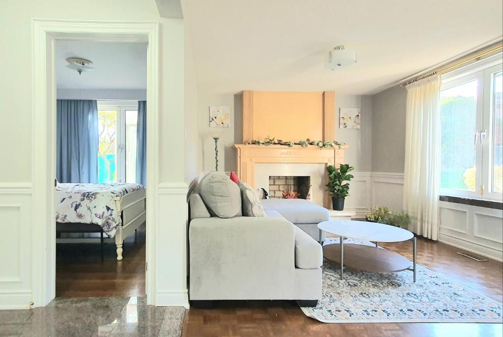 a living room with a white couch and a table at Deluxe Private Room in North York in Toronto