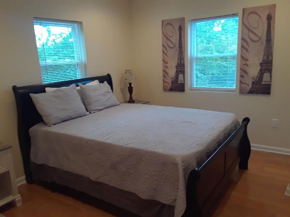 a large bed in a bedroom with two windows at Lovely 1-Bedroom/Near FedEx Field/Close to DC 