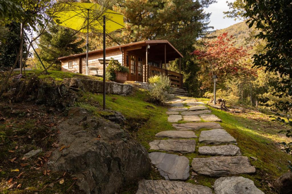 a stone path in front of a log cabin at Eco-Resort Parco Botanico Fiorlago in Mergozzo
