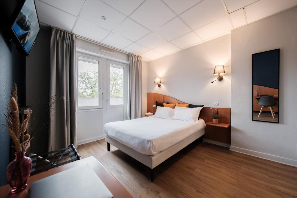 a hotel room with a bed and a window at Hôtel du Parc in Thionville