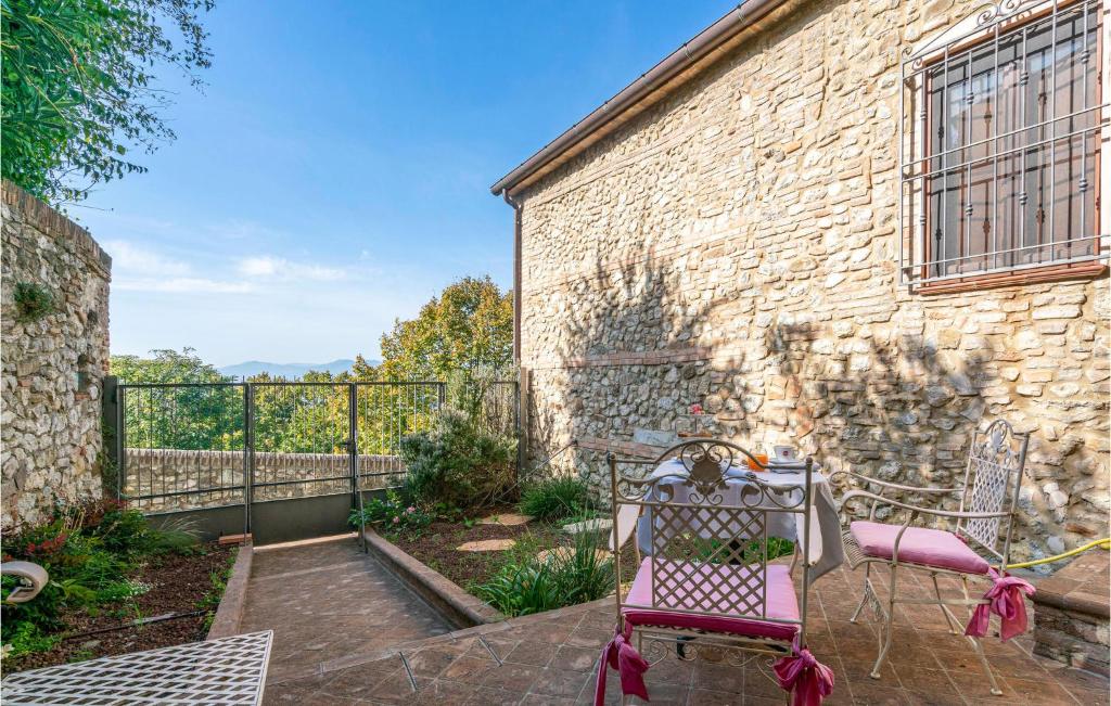 a patio with two chairs and a stone wall at Nice Apartment In Verucchio With Kitchen in Verucchio