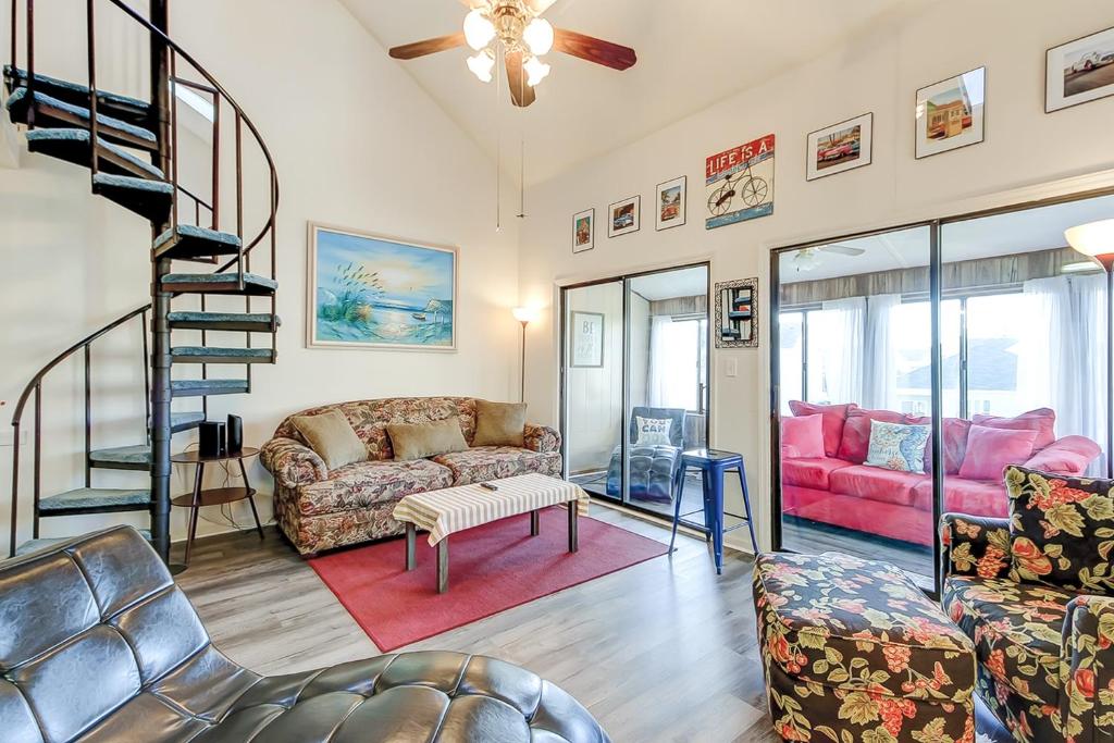 a living room with a couch and a spiral staircase at Fairway Village - B6 in Myrtle Beach