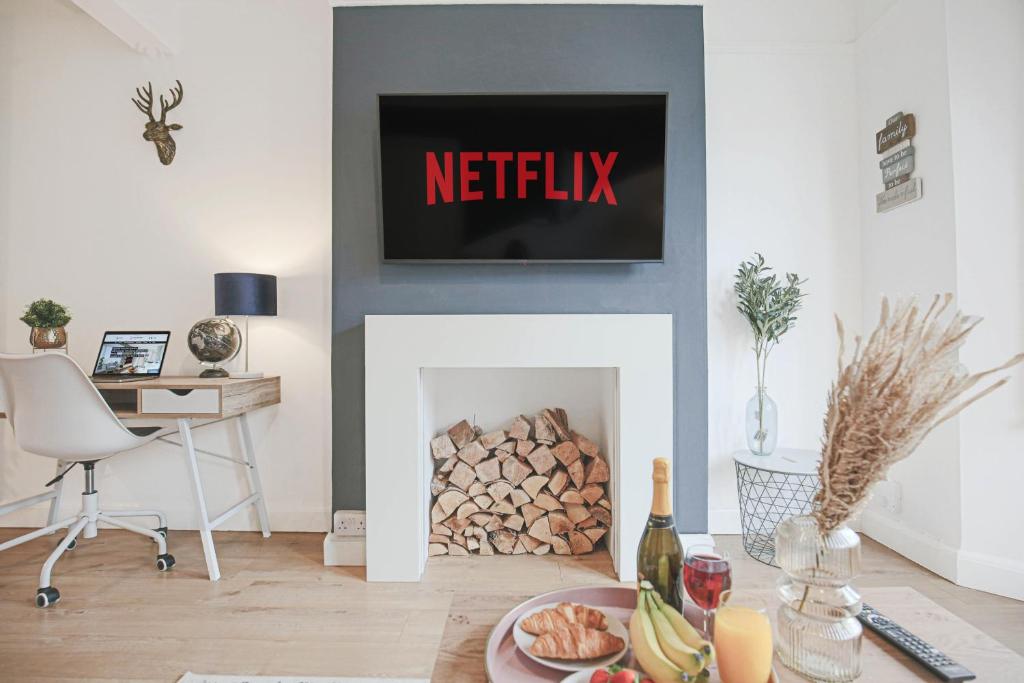 a living room with a fireplace with a tv above it at Central House with Free Parking, Garden, Super-Fast Wifi and Smart TVs by Yoko Property in Northampton