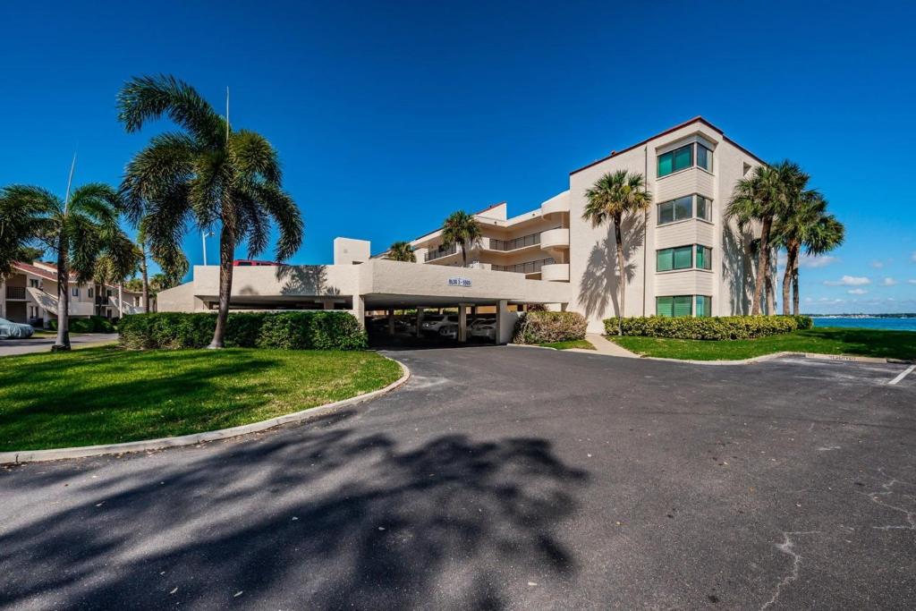 a building with palm trees in front of a street at La Puerta Island Retreat with Florida Flair in St Petersburg
