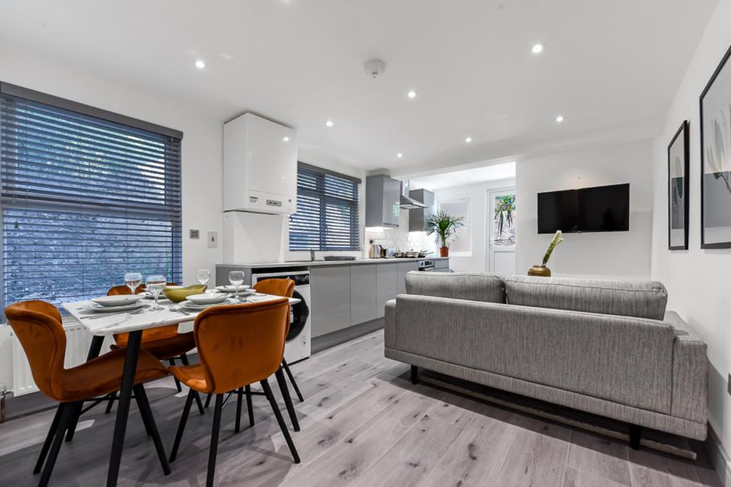 a living room with a couch and a table and chairs at Lovely 2 Bedroom Apartment in Greater London in London