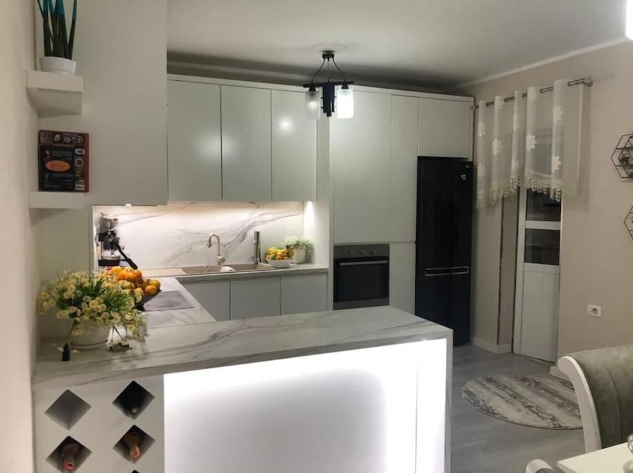 a kitchen with white cabinets and a counter top at Luxury appartment Citty center in Fier
