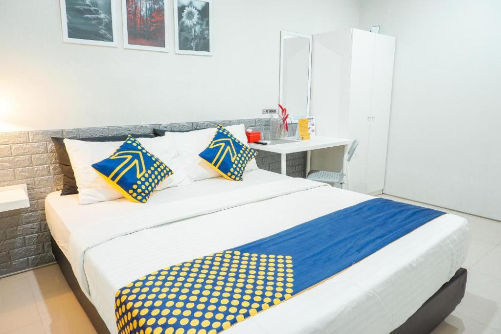 1 dormitorio con 1 cama grande con almohadas azules y amarillas en Rumah Teteh Syariah, en Bandung