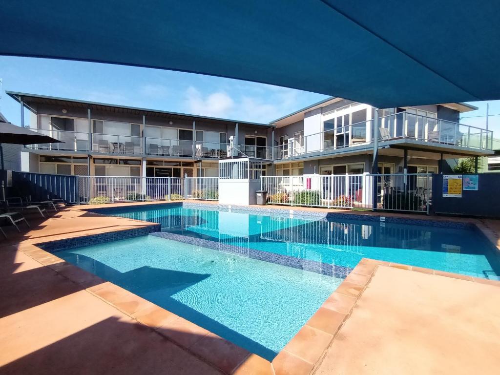 a swimming pool in front of a apartment building at Grandeur Holiday Units in Merimbula