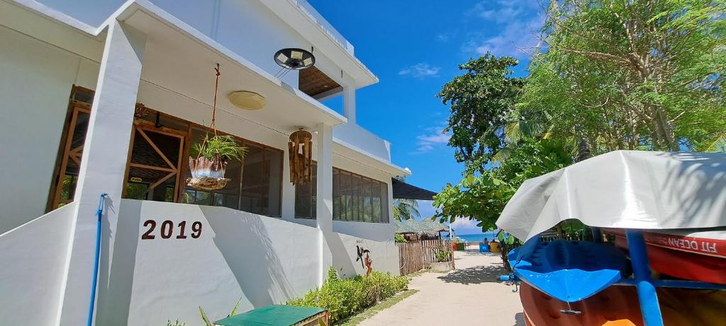 a house with a sign on the side of it at In Dai Aquasports and Beach Resort in Bantayan Island