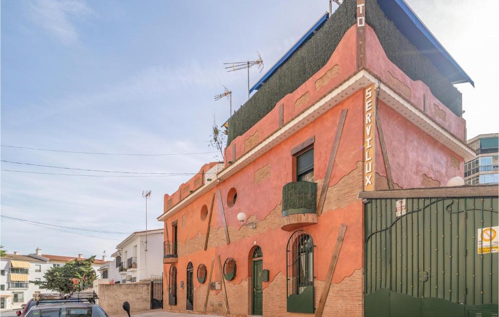 un edificio de ladrillo rojo con una puerta verde en una calle en Gorgeous Apartment In Torremolinos With Kitchen, en Torremolinos