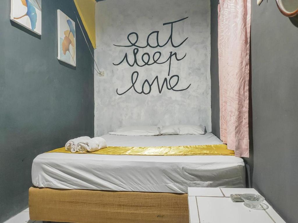 a bed with a sign that readsat new love at Yellow Sapphire RedPartner near Mayjend Sungkono in Surabaya