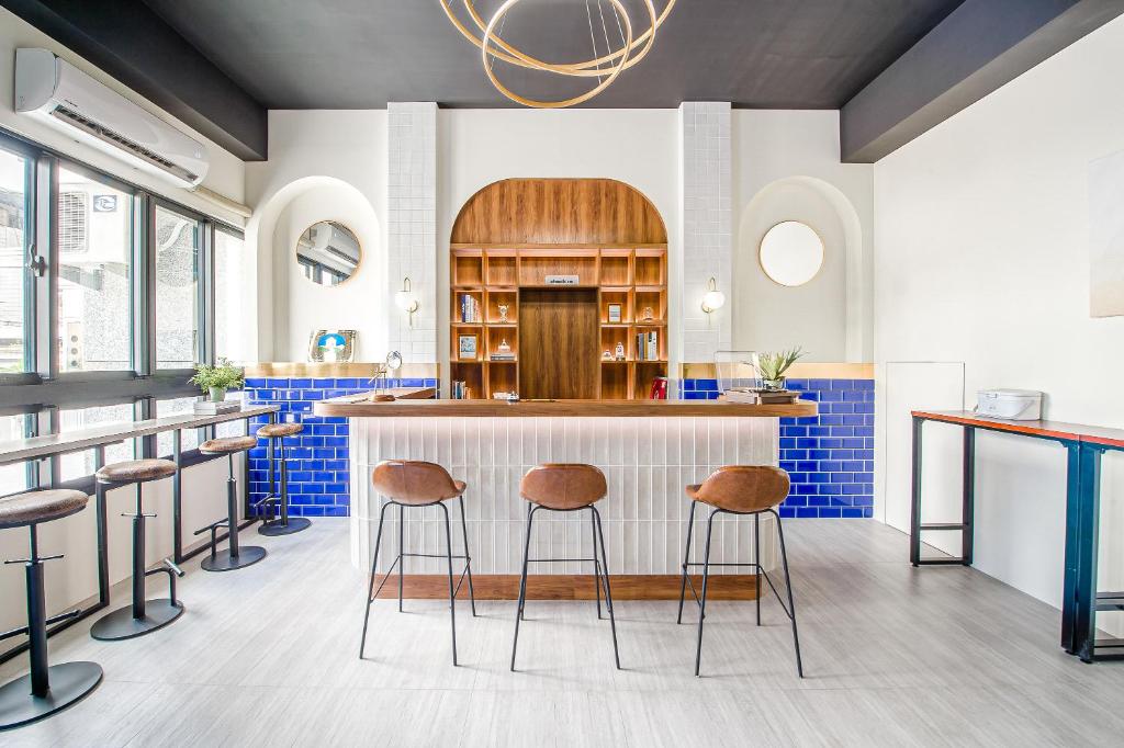 a kitchen with stools at a counter with blue tiles at H& Choco style inn in Taitung City