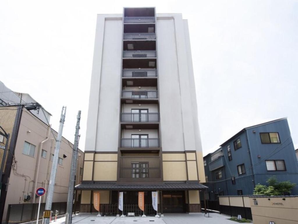 a tall building in a city with two buildings at Natural hot spring with sauna HOTEL GLAN Y's KOSHIGAYA in Koshigaya
