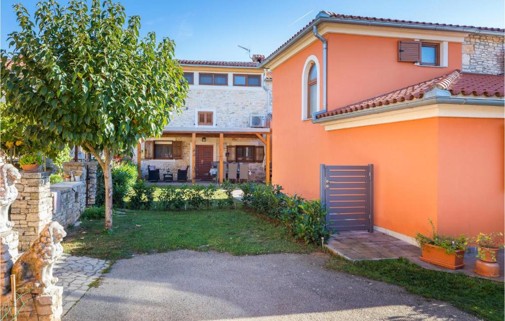 una casa de naranja con un patio con un árbol en 4 Bedroom Gorgeous Home In Vodnjan, en Vodnjan