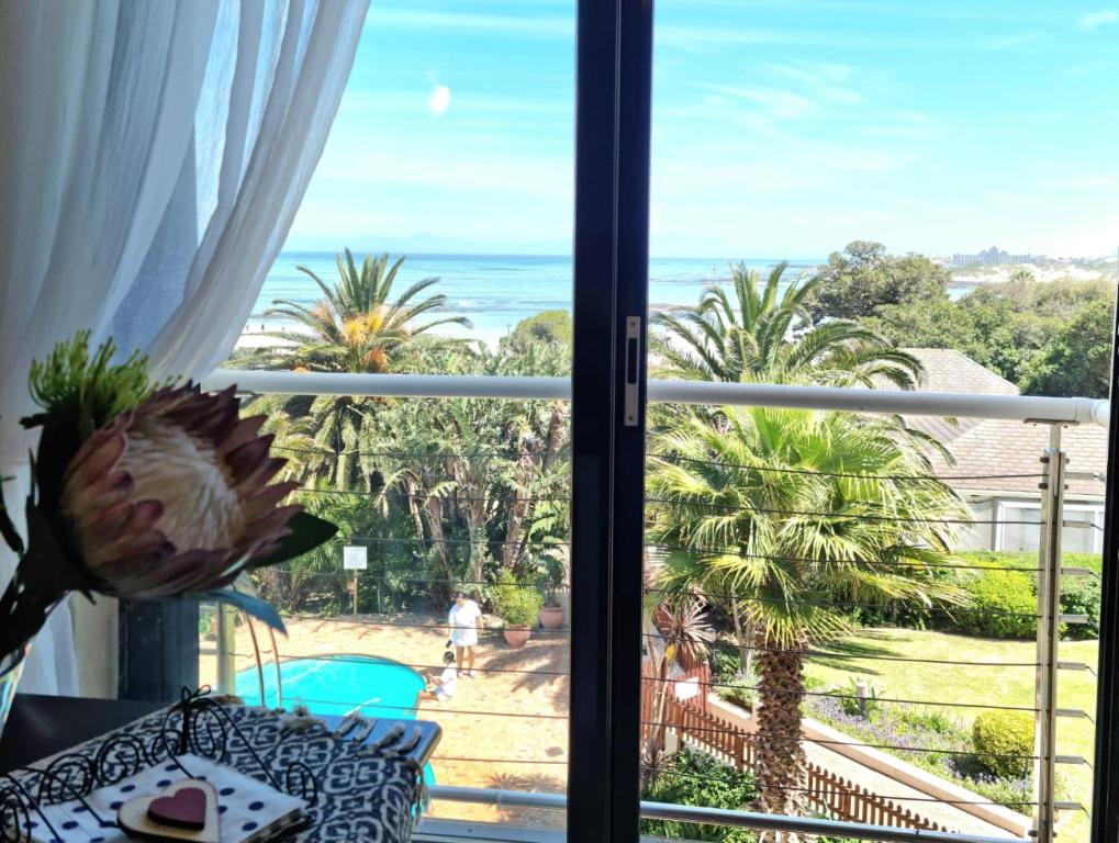 um quarto com vista para o oceano a partir de uma janela em Apartment18Lifestyle Gordons Bay Beachfront em Gordonʼs Bay