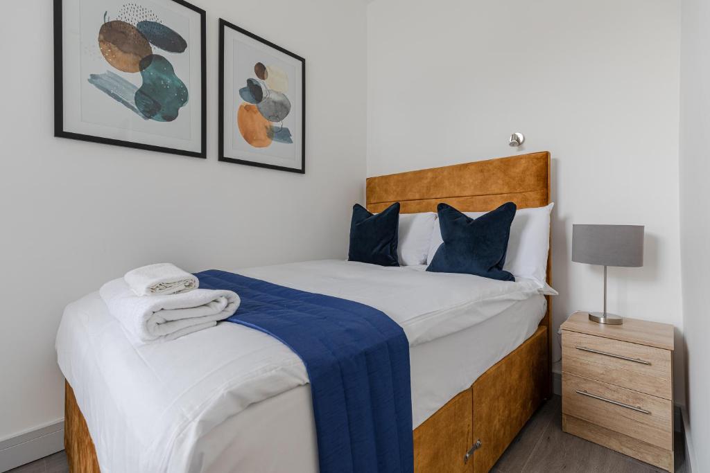 a bedroom with a large bed with a blue blanket at Dainty 2BD Flat in Greater London in London