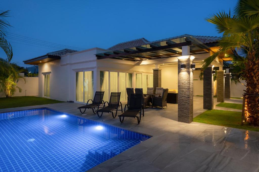 a villa with a swimming pool at night at Orchid Paradise Homes OPV428 in Hua Hin