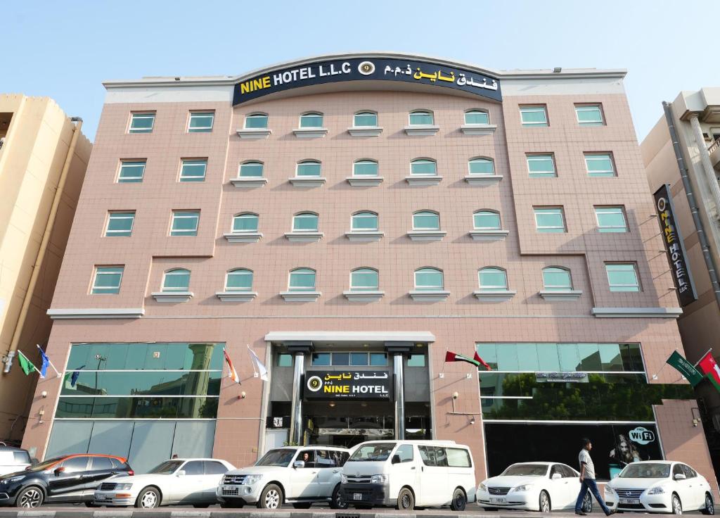 un bâtiment avec des voitures garées devant lui dans l'établissement Nine Hotel, à Dubaï
