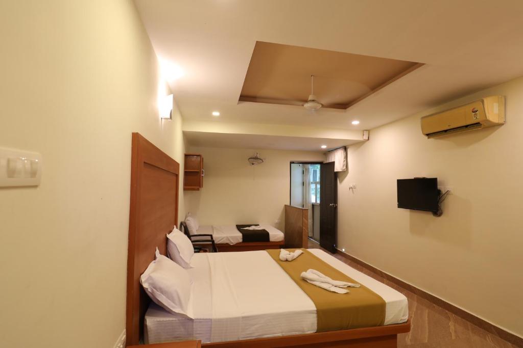 a hotel room with a bed in a room at Hotel Rydham in Madurai