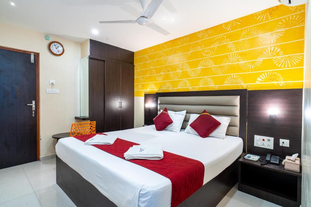 a bedroom with a large bed with a red blanket at Safa Residency in Tiruchchirāppalli