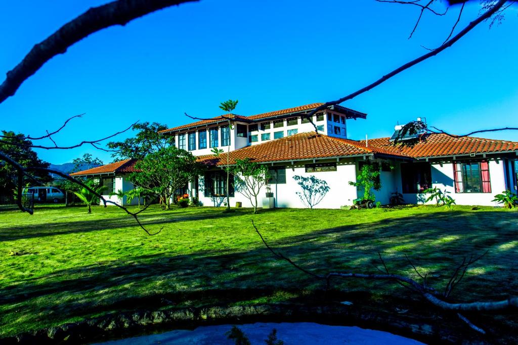 a house with a green lawn in front of it at Two Acre Private Costa Rican Villa Volcano Views Gym Hot Tub in Atenas