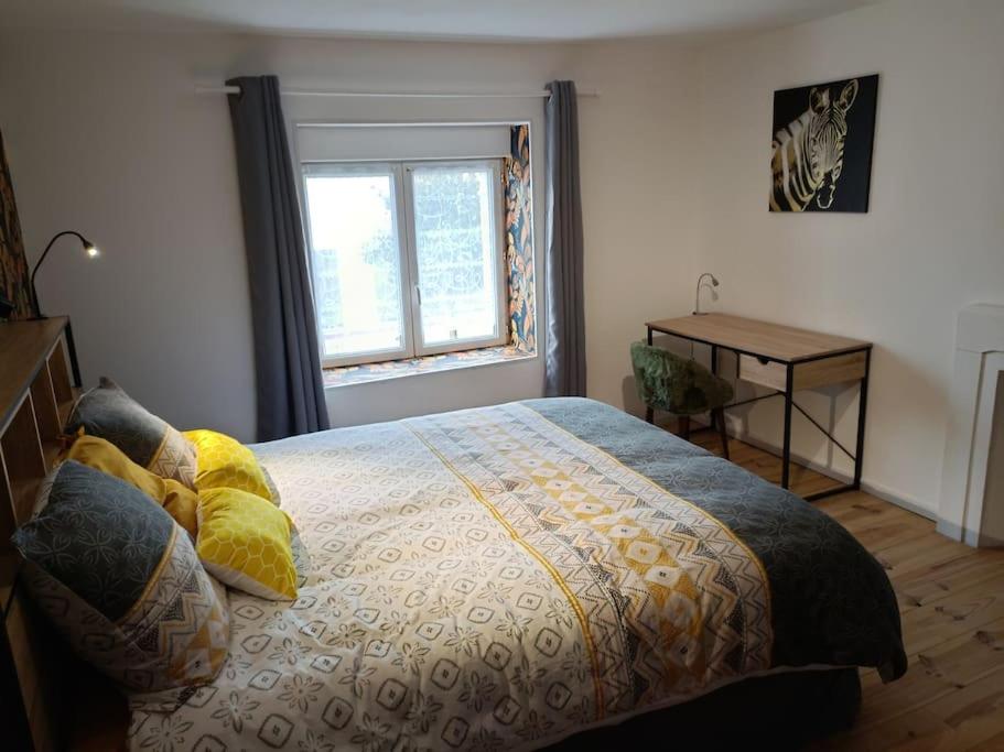 - une chambre avec un lit doté d'oreillers jaunes et d'une fenêtre dans l'établissement T2 entre Quimper et Concarneau, proche gare., à Rosporden