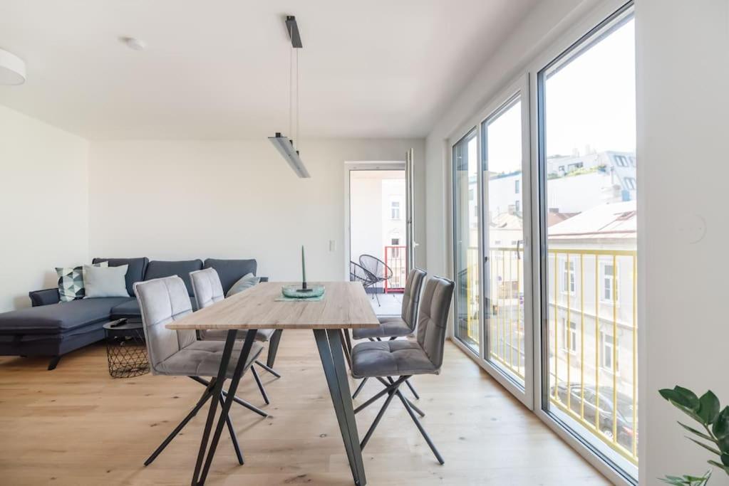 salon ze stołem, krzesłami i kanapą w obiekcie Grüne und zentrale Ruhelage im Neubau mit Balkon w Wiedniu