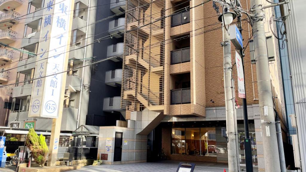 un grand bâtiment dans une rue de la ville avec un éclairage de rue dans l'établissement Toyoko Inn Kagoshima Temmonkan No 1, à Kagoshima