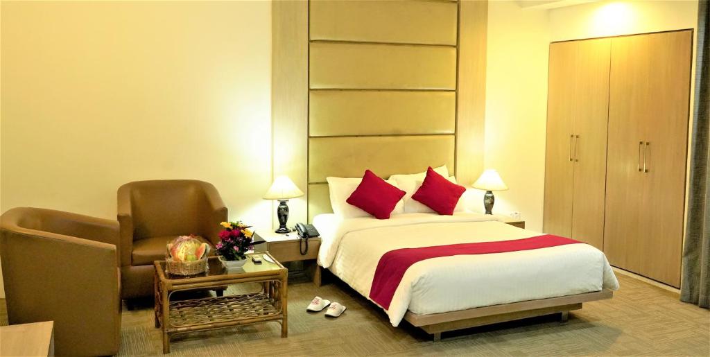 Pokój hotelowy z łóżkiem i krzesłem w obiekcie Asia Pacific Hotel w mieście Dhaka