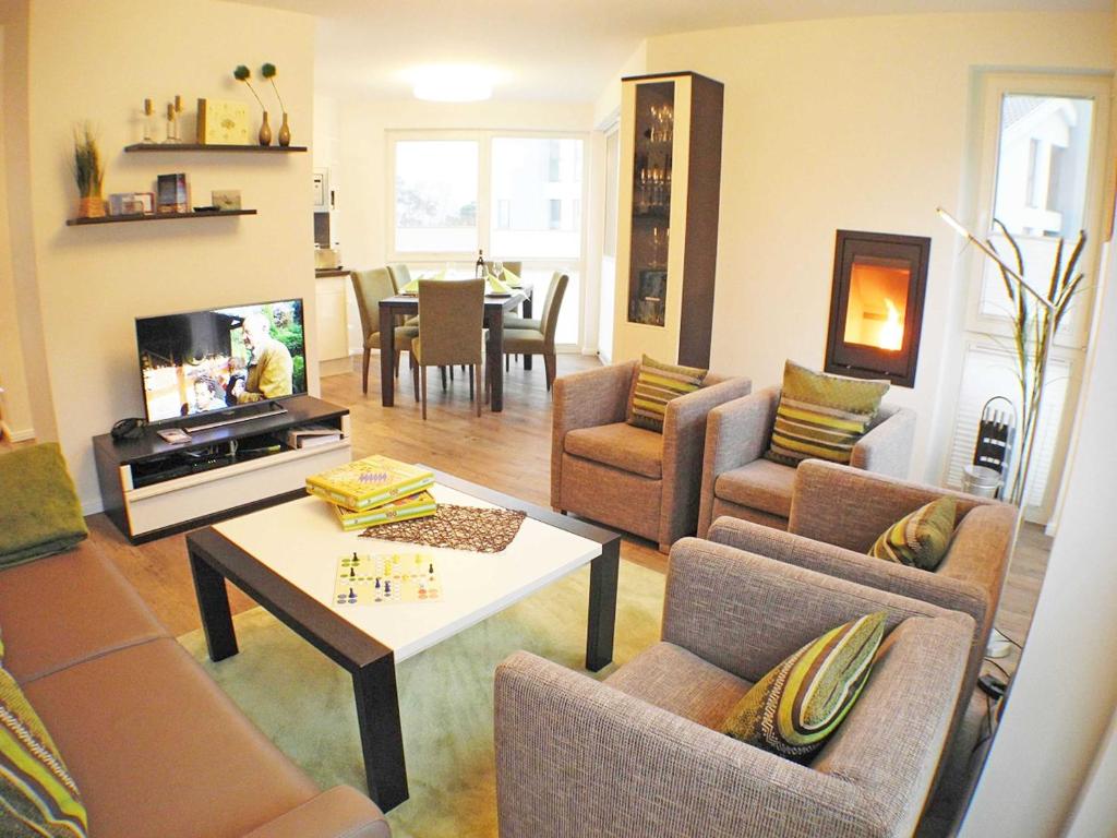 a living room with couches and a table and a tv at Strandvilla Baabe - Maisonette "Sonnenwiege" mit Sauna und Whirlpool in Baabe