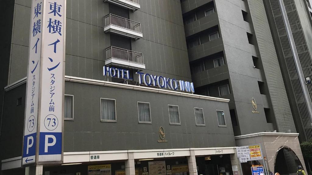 橫濱的住宿－Toyoko Inn Yokohama Stadium Mae No 2，一座高大的建筑,旁边有一个标志