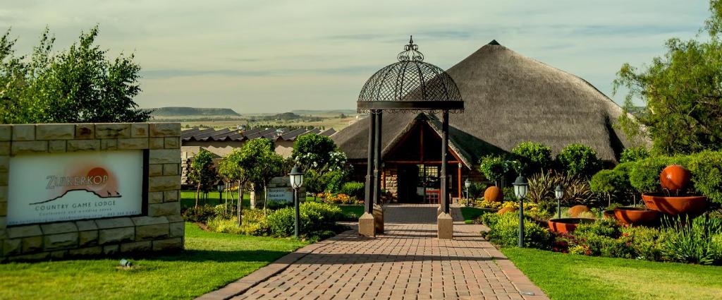 a pavilion in a garden with a sign in front of it at Zuikerkop Country Game Lodge in Clocolan
