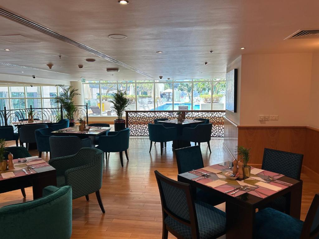 a restaurant with tables and chairs in a room at Nuran Marina in Dubai